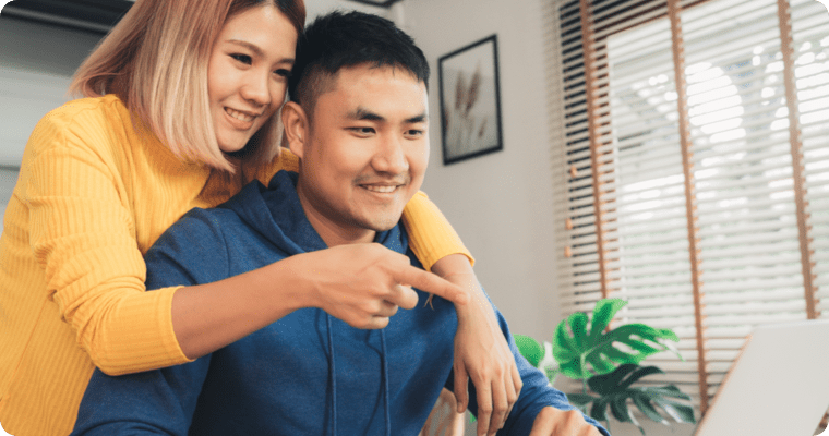Photo d’un couple consultant un ordinateur portable en souriant