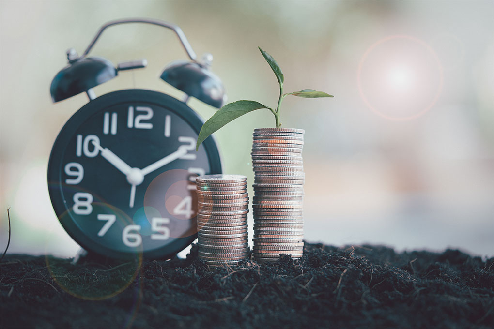 Horloge noire avec pièces et plante en croissance