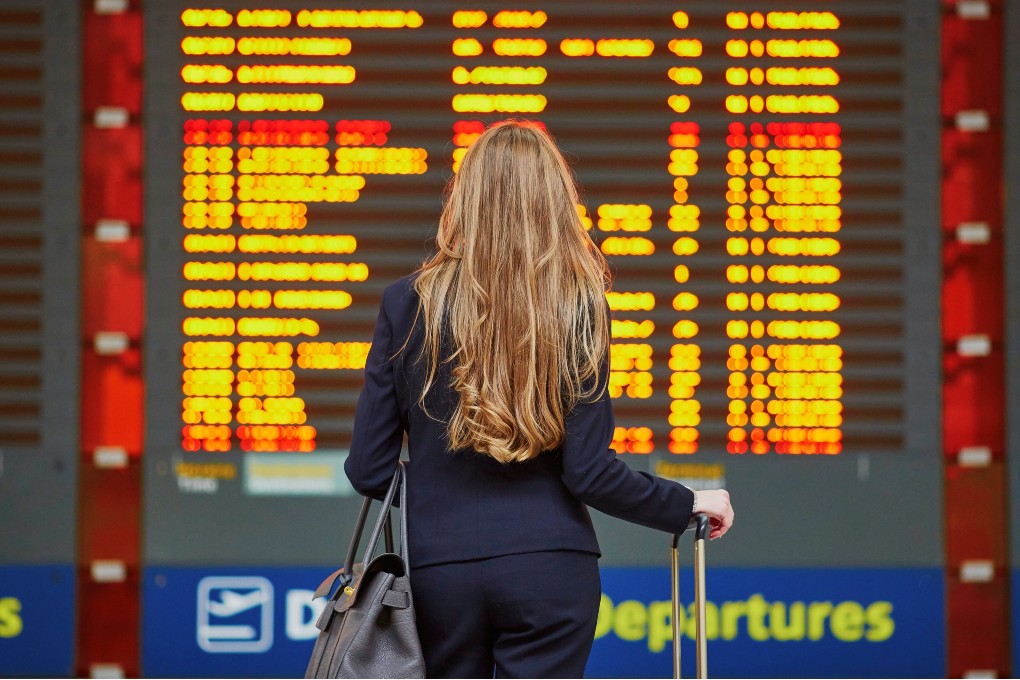 Une dame à l’aéroport qui consulte les heures de vol.